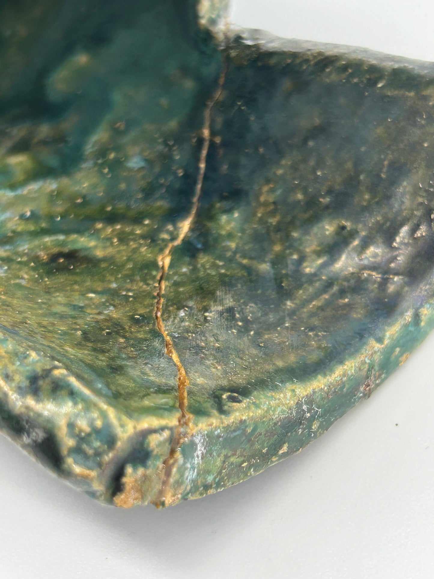 image of small crack of Small Statue of a creature with mottled green glaze