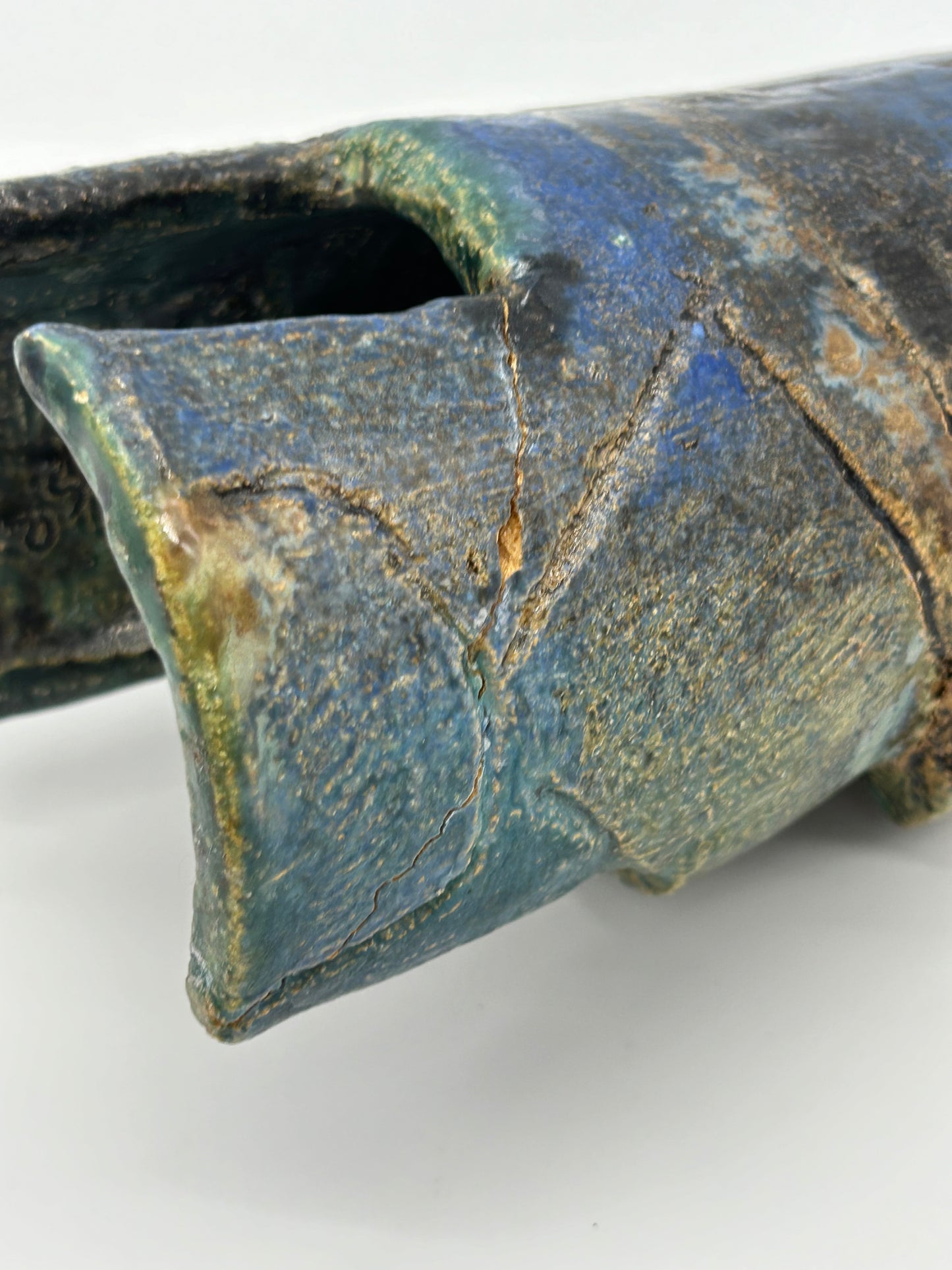 view of damage of Small Statue of a creature with mottled green glaze