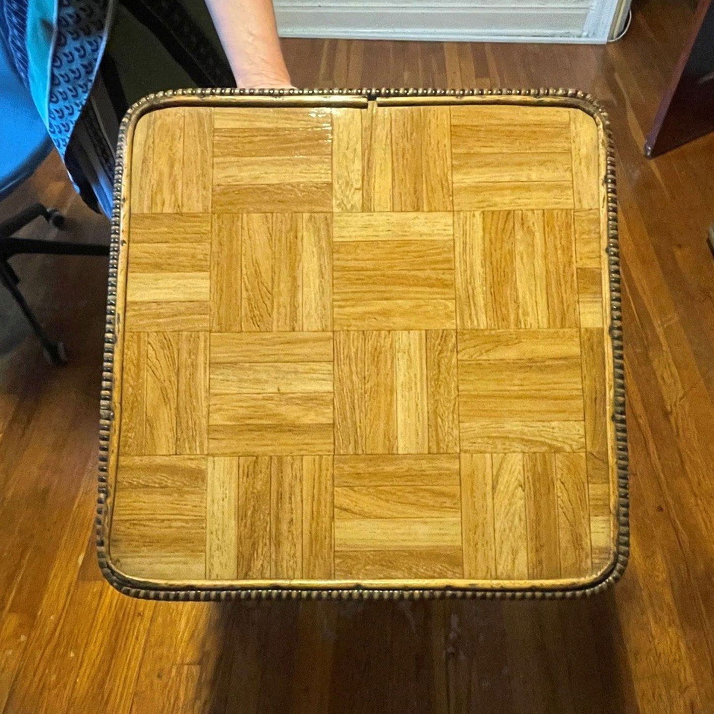 Wooden table top with a checkered pattern on a wooden floor