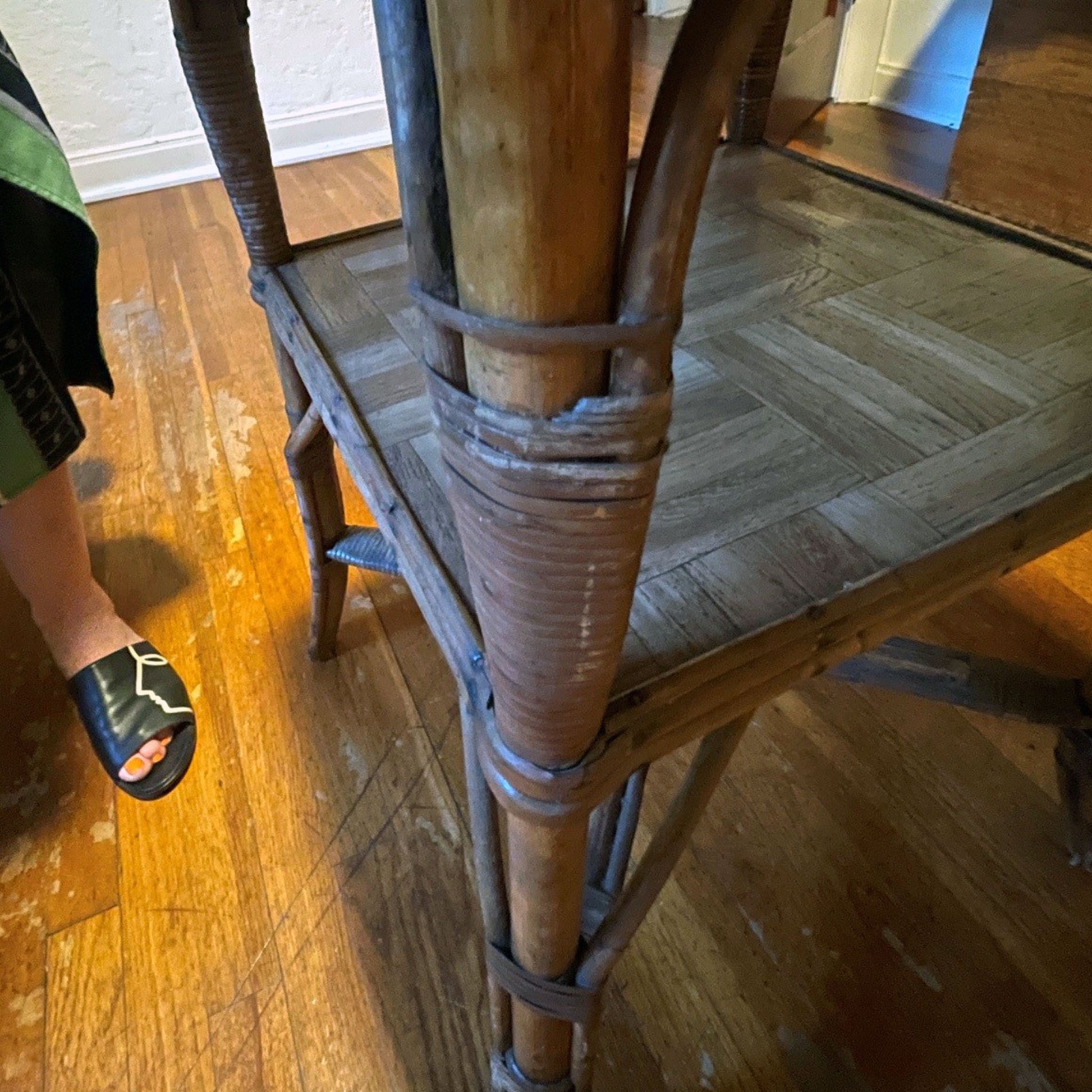 Wooden table leg showing missing trim on a wooden floor
