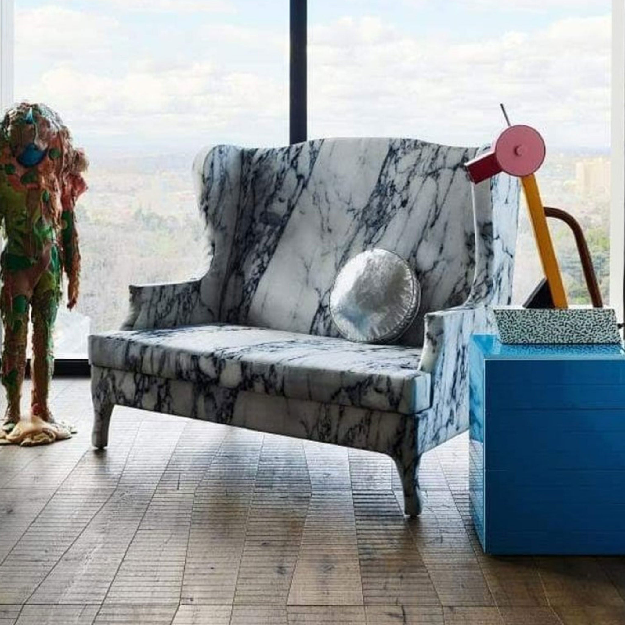 An antique settee upholostered with modern marble print fabric accompanied by some unique found objects.